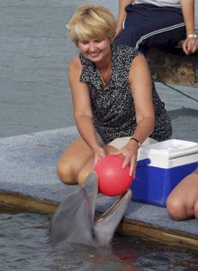 Woman playing ball with dolphin